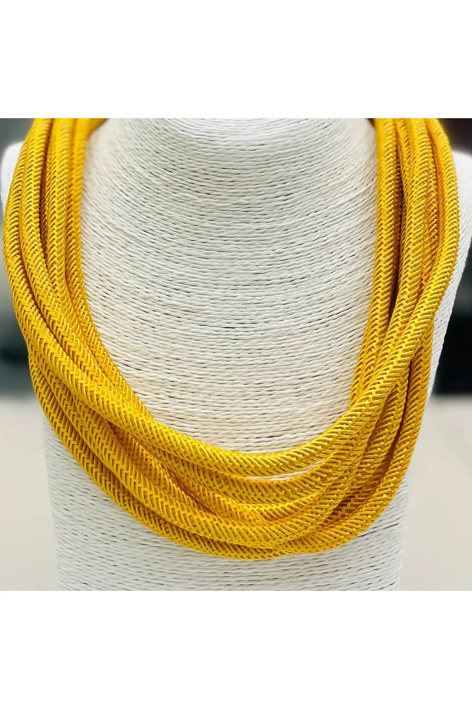 Golden yellow strand necklace on a mannequin.