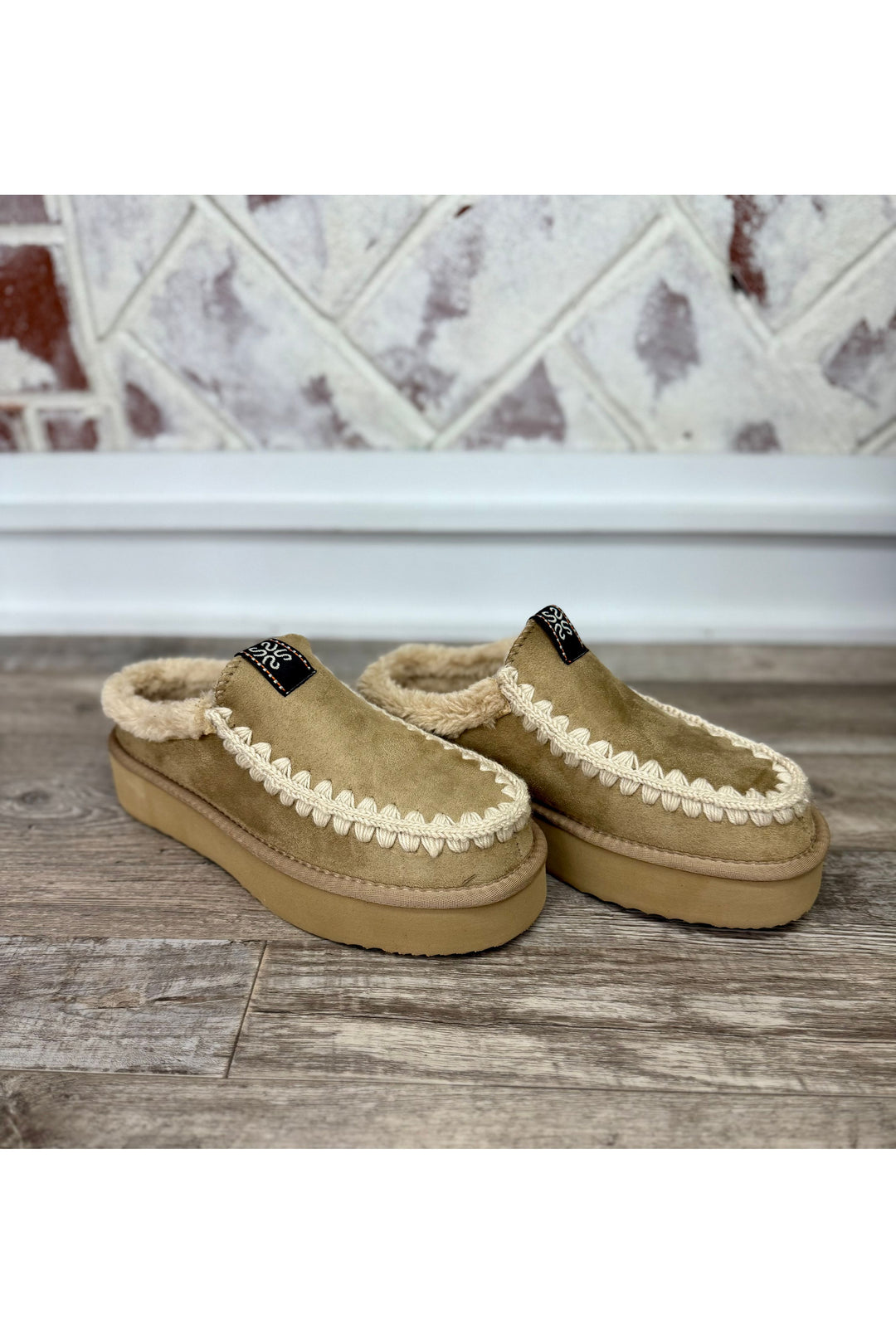 Tan slide with faux fur on inside with cream stitching on outline of shoe