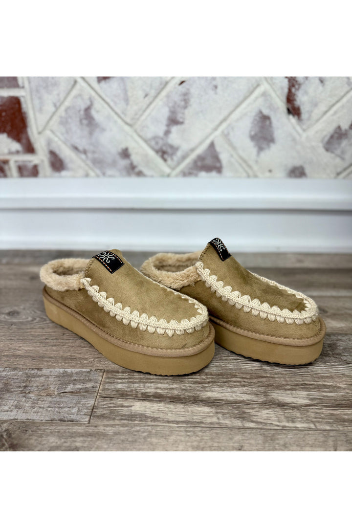 Tan slide with faux fur on inside with cream stitching on outline of shoe