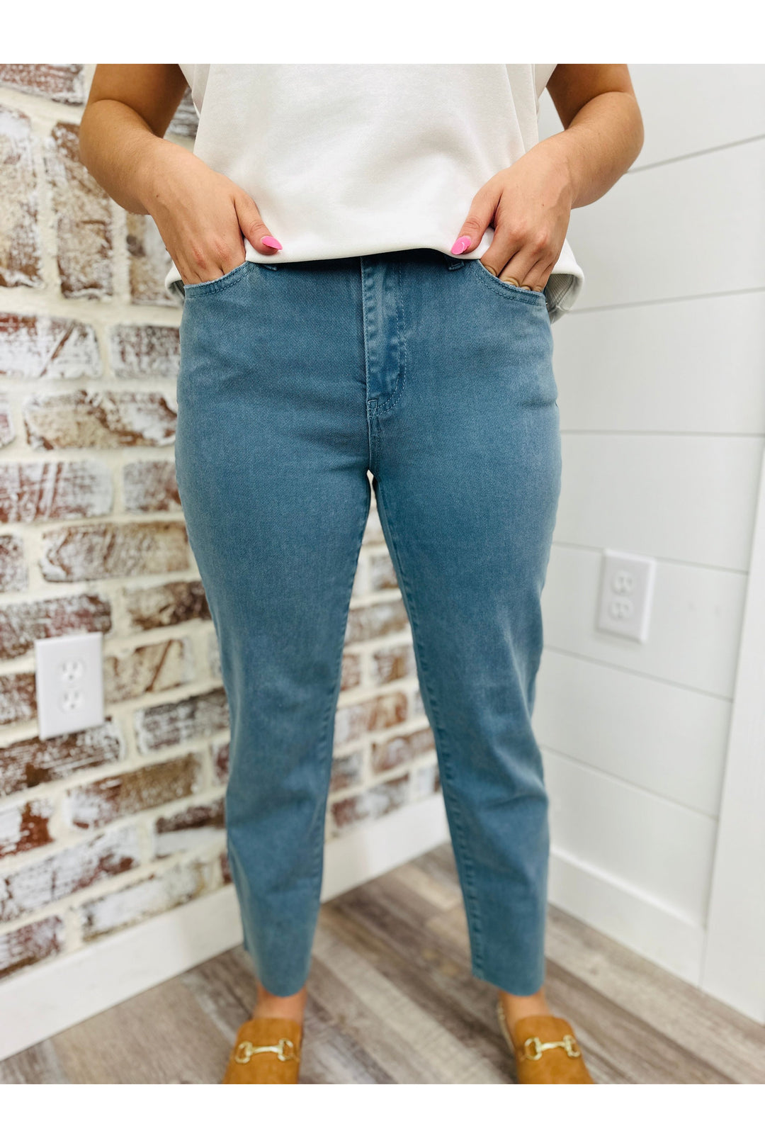 Woman wearing teal high rise straight leg pants with a top.