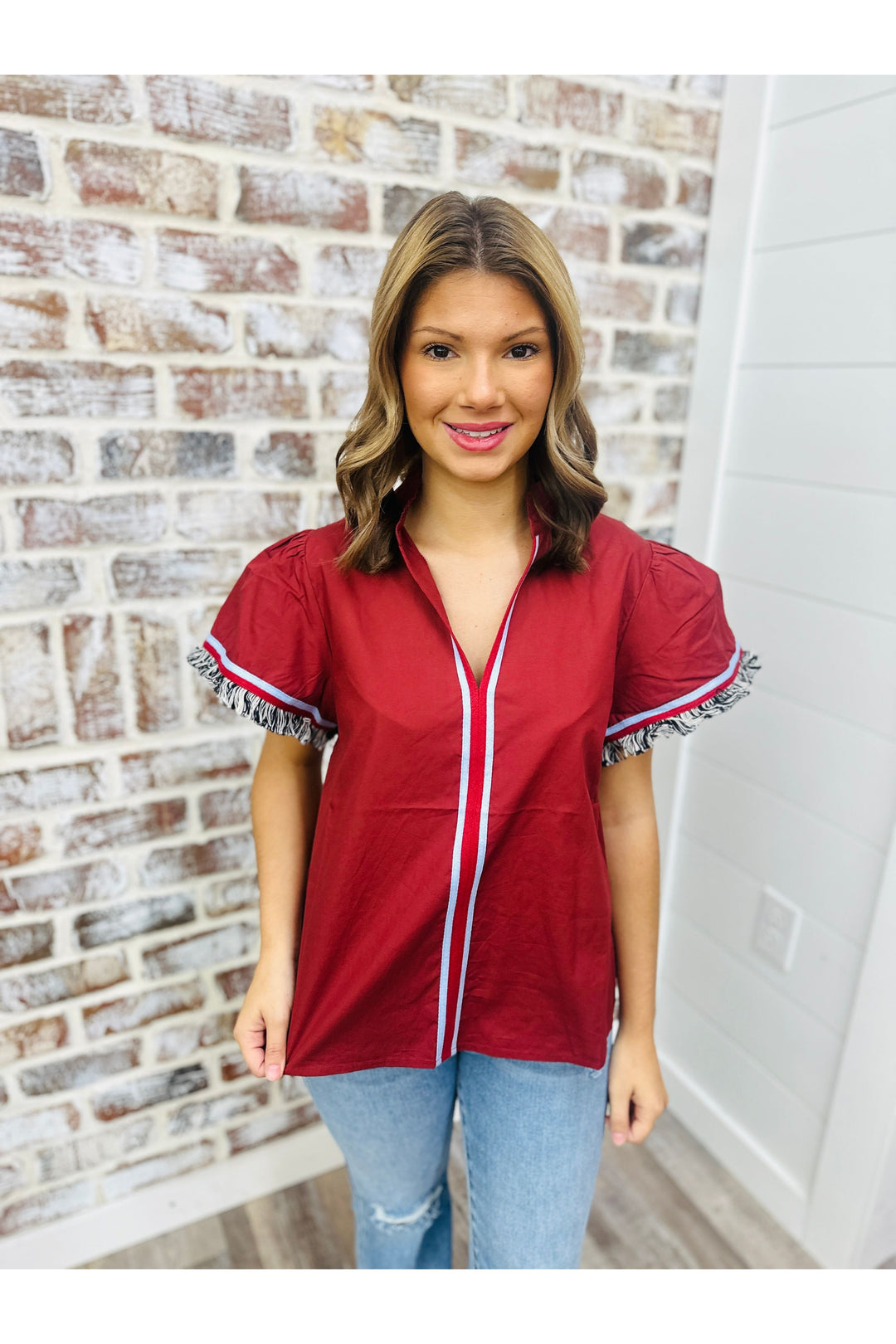 Wine color with fringe on sleeves with blue stripe in middle and around fringe 