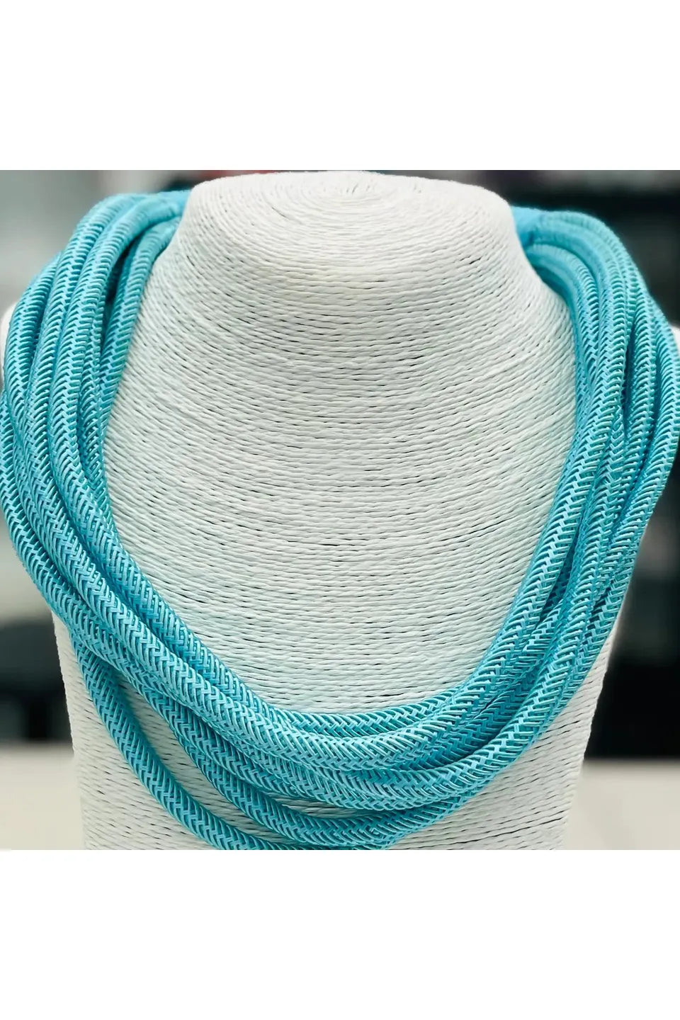 Teal stand necklace on mannequin