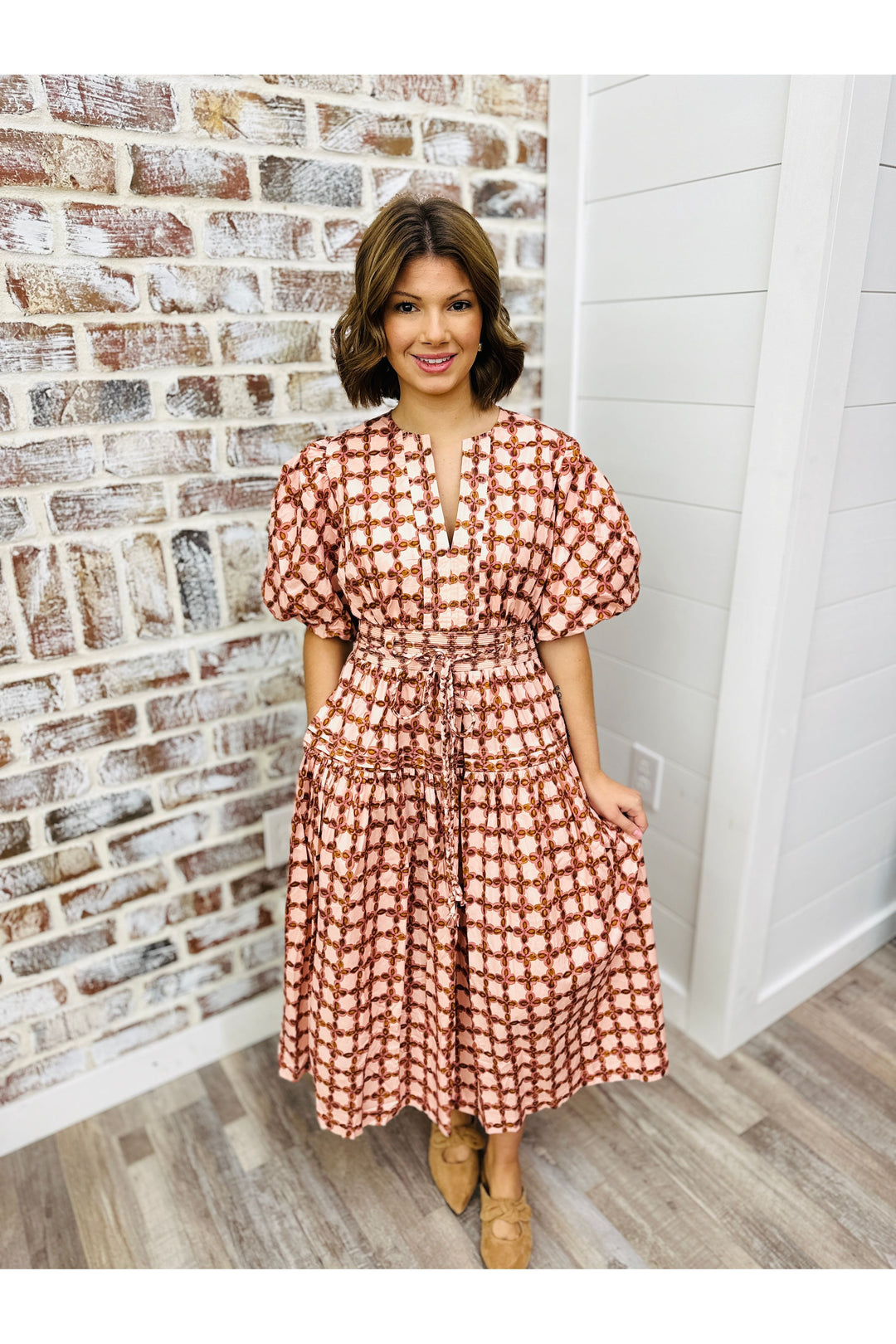 Blush colored midi dress with design detail.