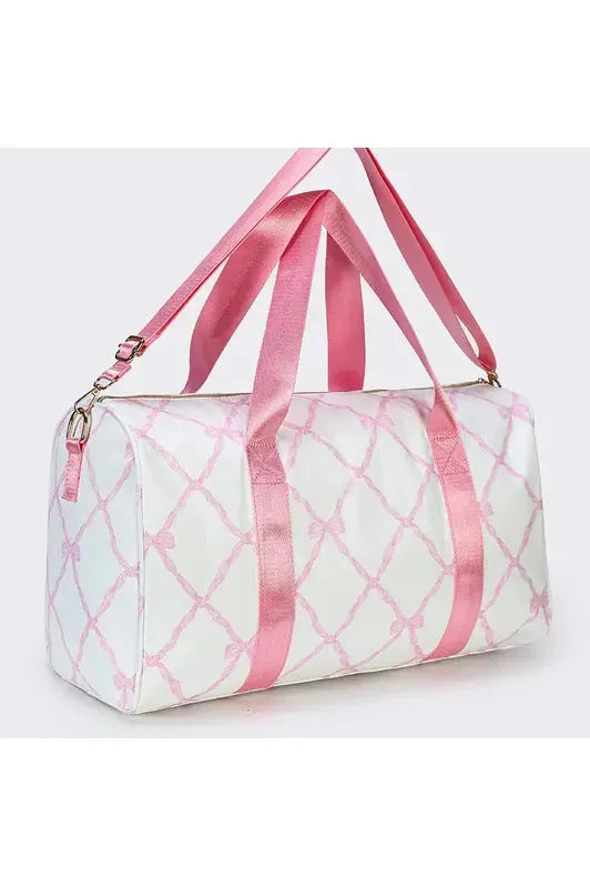 White duffle bag with light pink printed bows and pink straps.