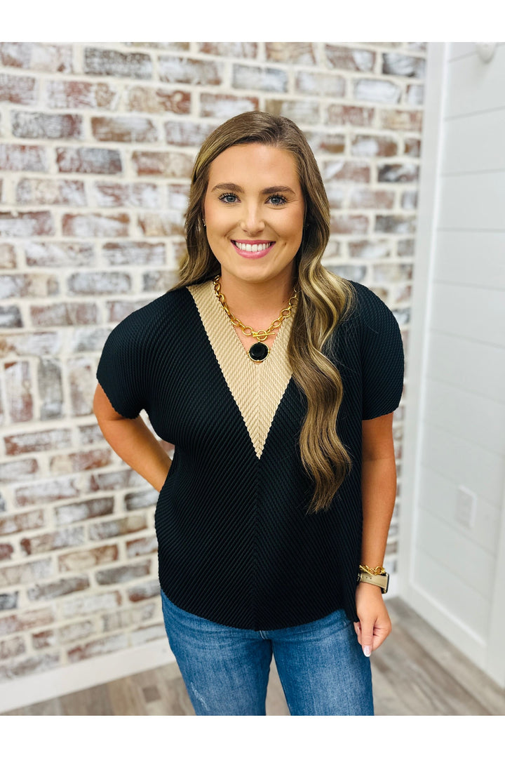 black short sleeve pleated design top with beige contrasting neckline