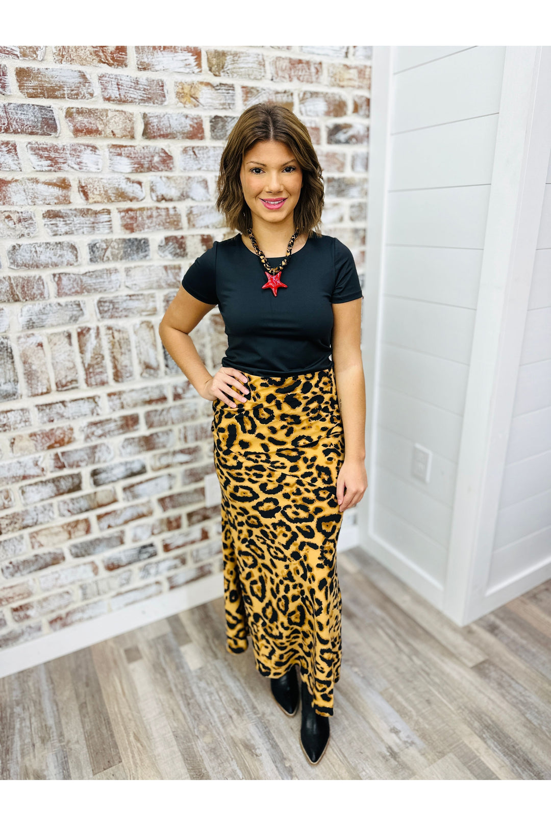 Woman wearing leopard print maxi skirt paired with black top.