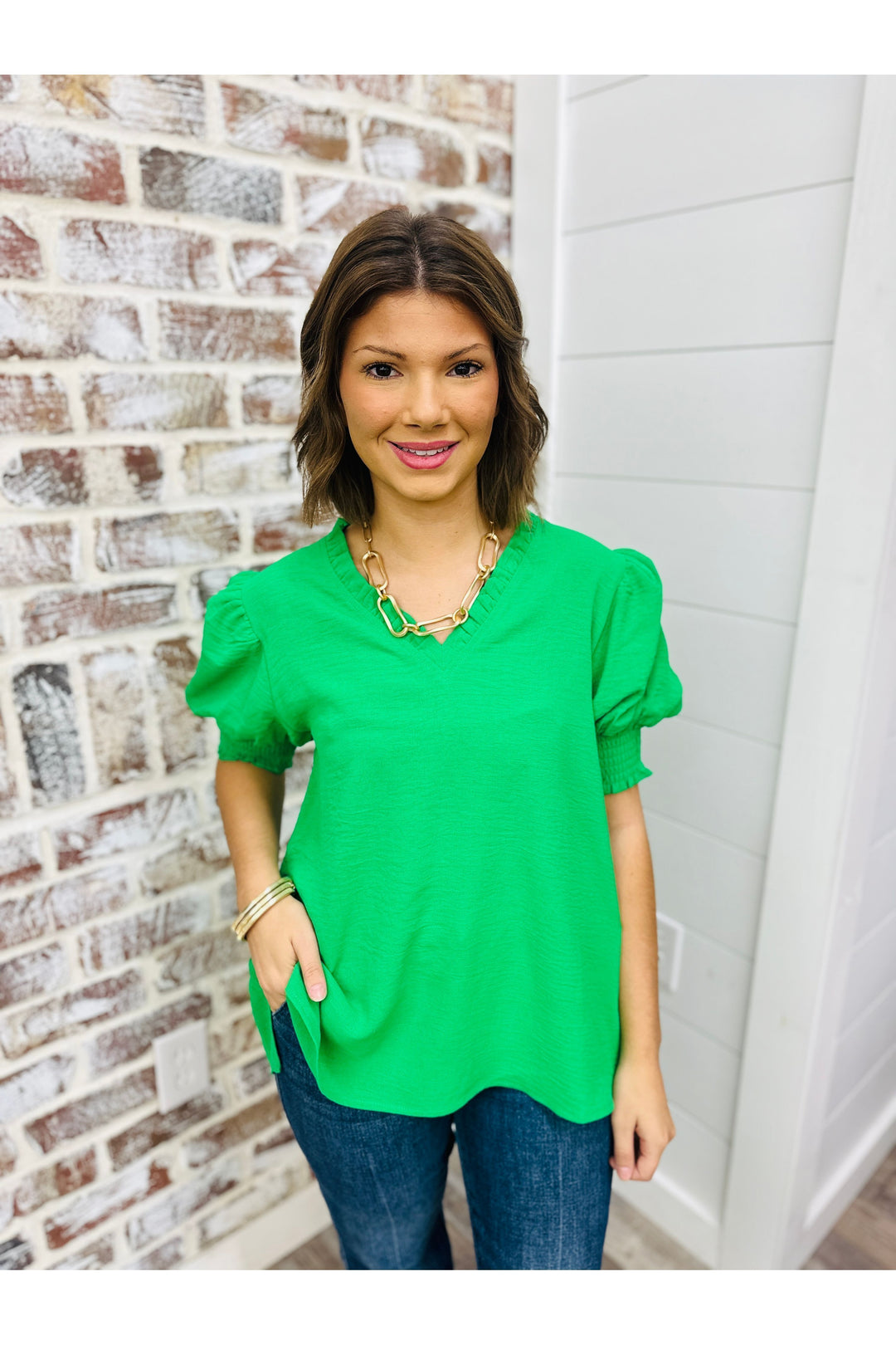 Woman wearing Kelly green puff sleeve top 