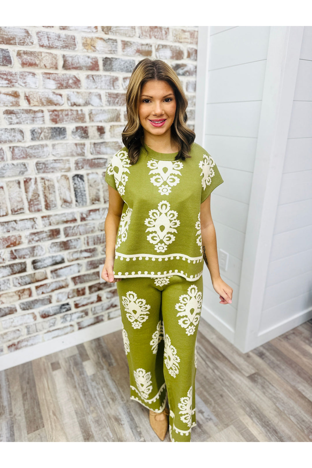 Woman wearing an olive and cream detailed pants set.