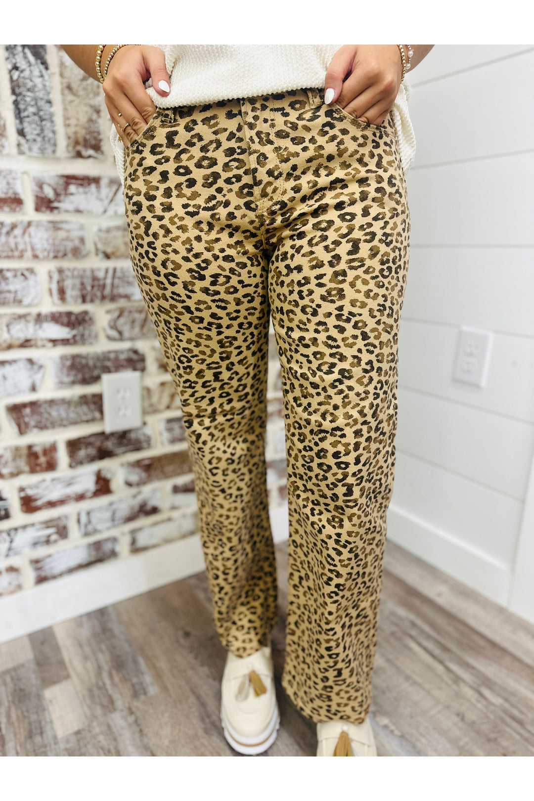 Woman wearing leopard mid rise ankle straight jeans with a cream top.