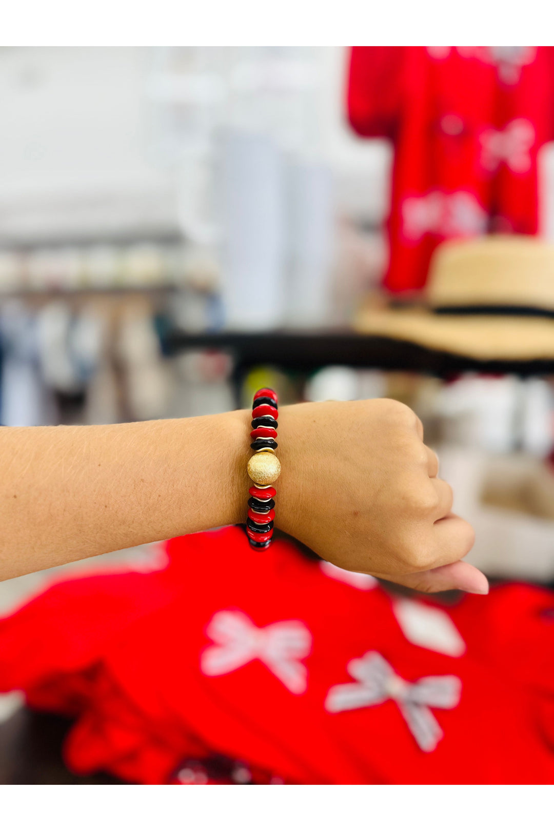 Red and black beaded bracelet with gold stud bead in the middle.
