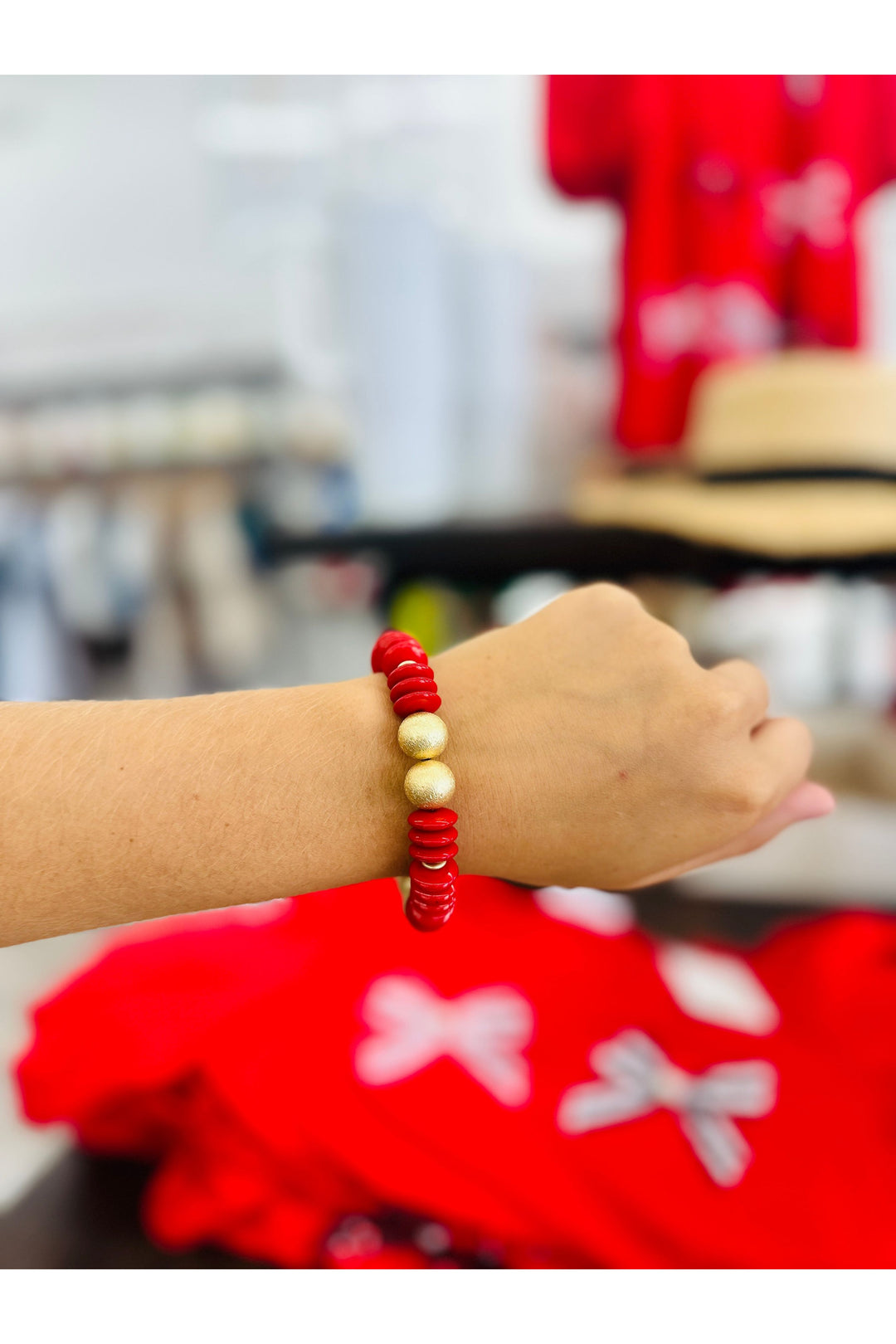 Red beaded bracelet with 2 gold beads.