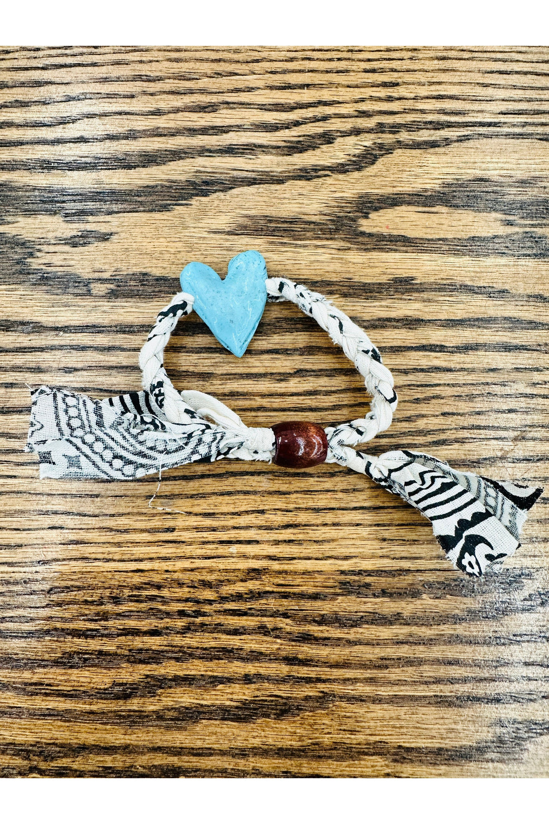 Black and white braided scarf bracelet with turquoise heart charm.