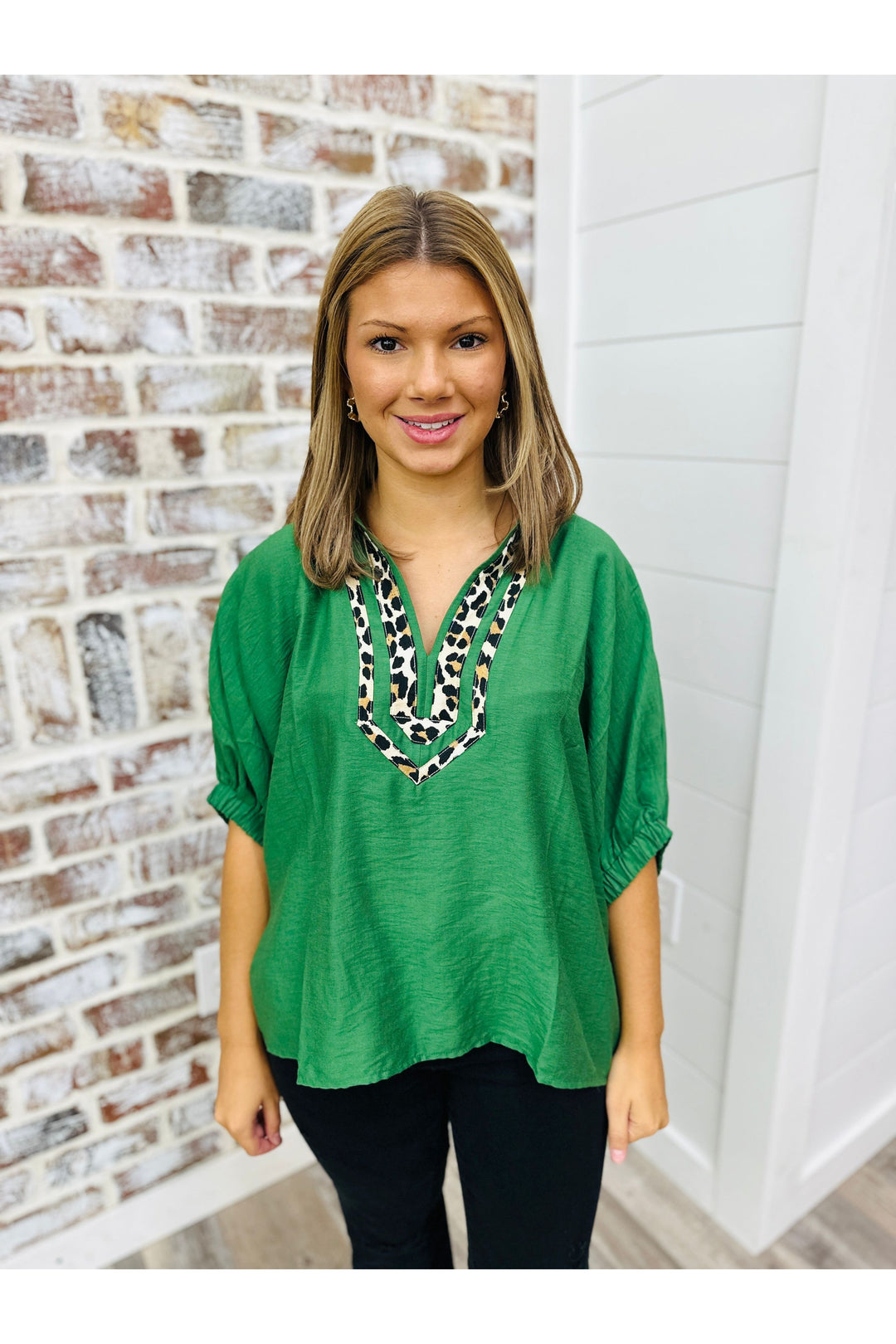 green short sleeve top with leopard design around the v-neck