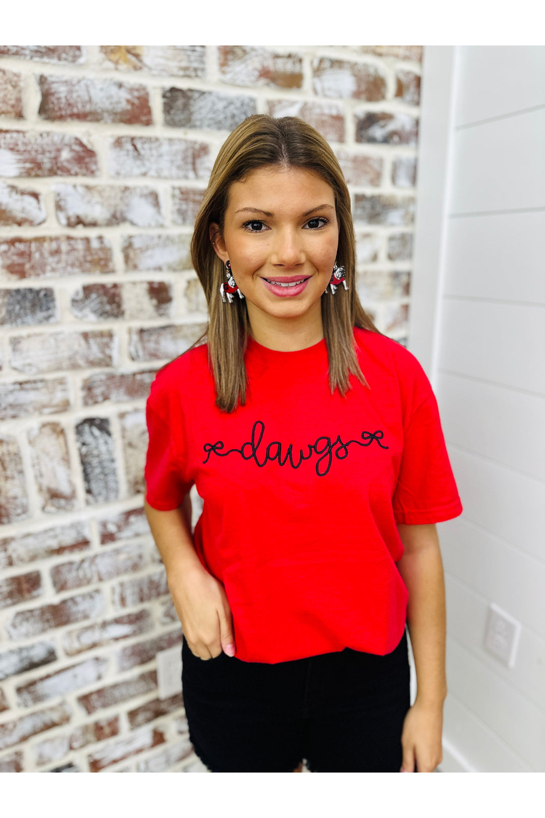 Red solid tee with black embroidered dawgs with bow design.