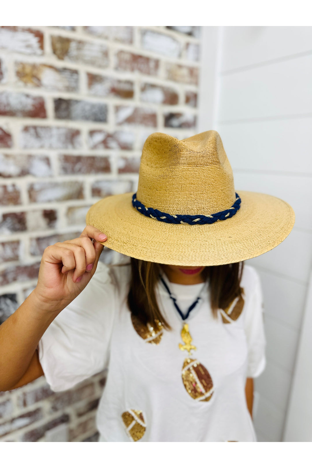 Tan Tipsy Threads brand hat with navy rope with gold detail.
